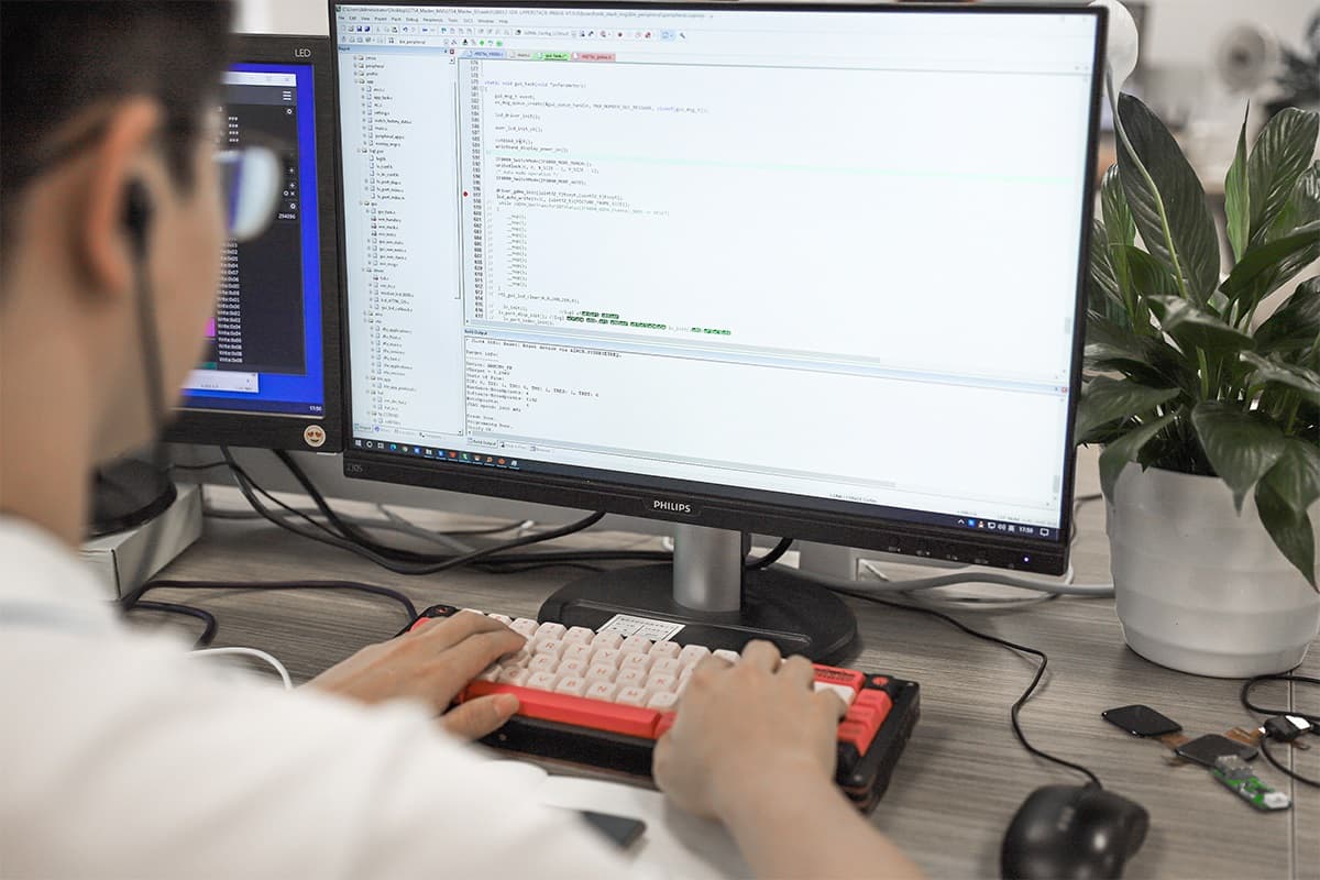 Engineers at an oscilloscope bench developing wearable firmware and hardware
