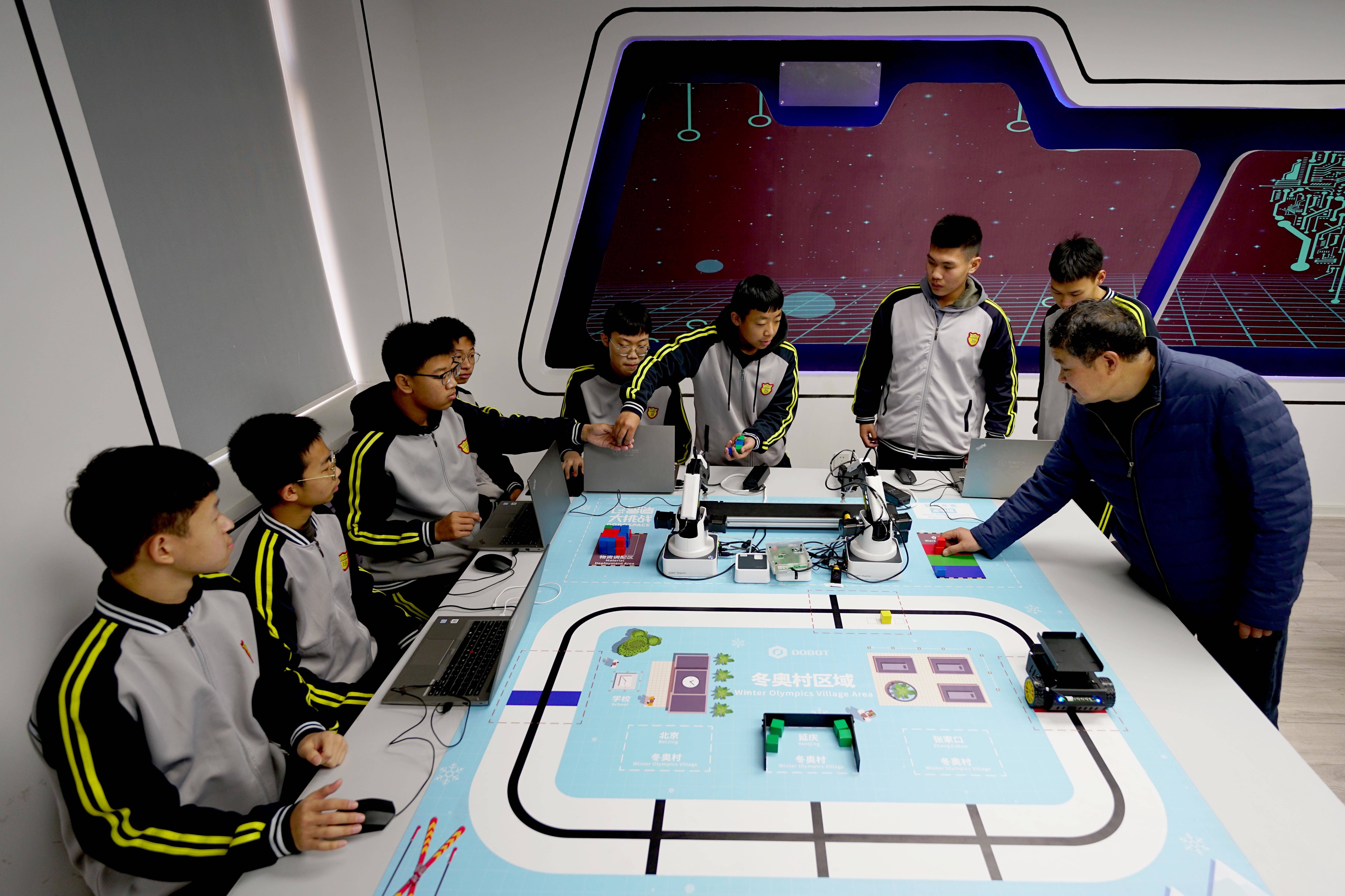 Several small educational robots arranged on a classroom table