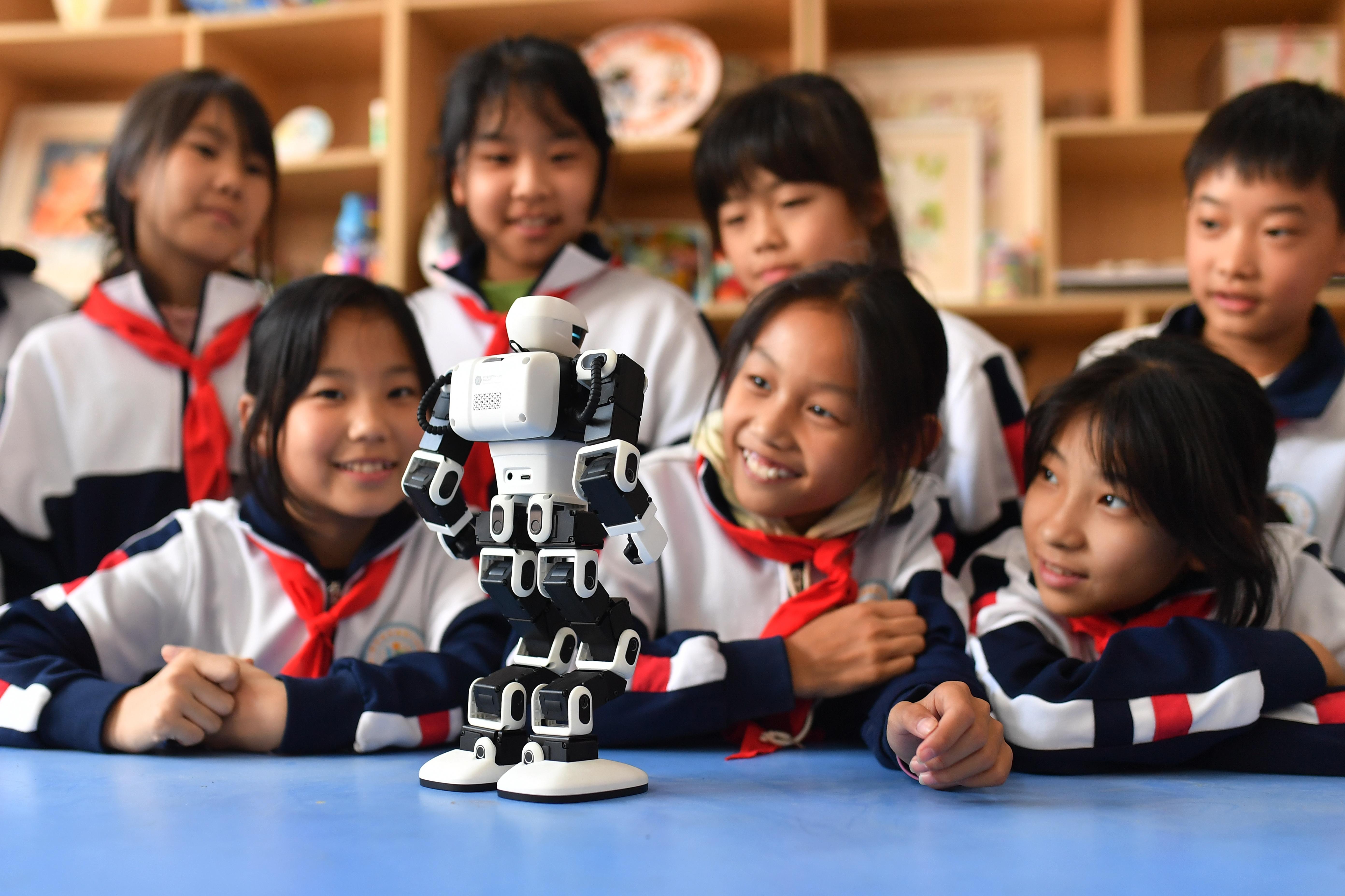Child interacting with the E1 learning robot at a desk